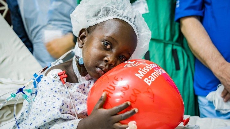 La piccola Jackline Nanusolo in sala operatoria, con sullo sfondo il team medico di Mission Bambini